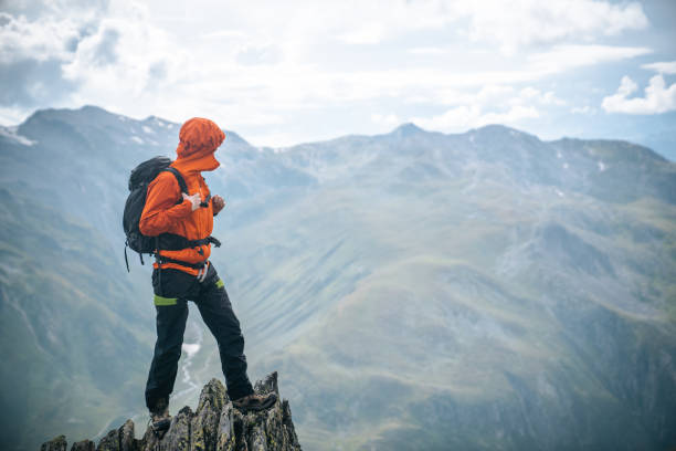 альпинист взбирается на вершину вершины - risk mountain climbing climbing conquering adversity стоковые фото и изображения