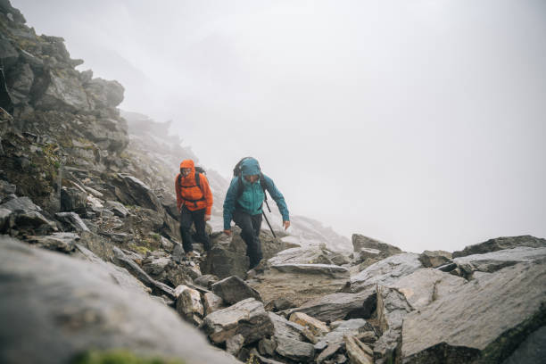 gli alpinisti si arrampicano su una cresta rocciosa - conquering adversity mountain hiking mountain climbing foto e immagini stock