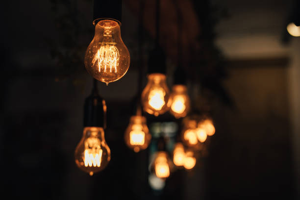 istock Lamp bulbs hanging on a dark background. 1367406246