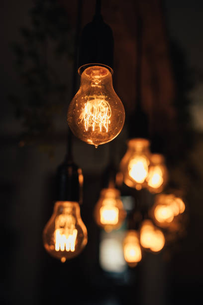 istock Lamp bulbs hanging on a dark background. 1367406252