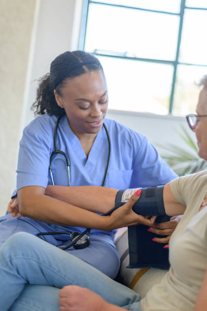 istock Home health aide checking patient's blood pressure 1367408218