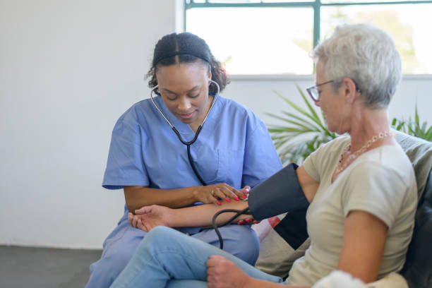 istock Home health aide checking patient's blood pressure 1367408221