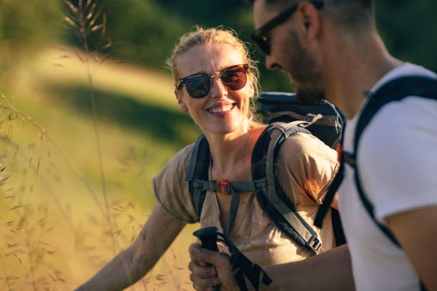 porträt einer schönen frau, die beim wandern mit ehemann lächelt - family summer portrait nature stock-fotos und bilder