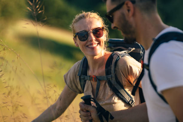 ritratto di una bella donna sorridente durante un'escursione con il marito - family summer portrait nature foto e immagini stock