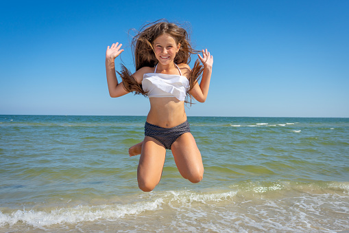 girl with open arms staying on the seashore