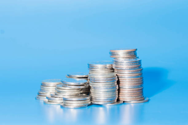 a stack of silver coins on a blue background - 4742 imagens e fotografias de stock