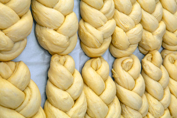 Raw sweet braided bread in fermentation Raw sweet braided bread in fermentation waiting to enter bakery oven braided buns stock pictures, royalty-free photos & images