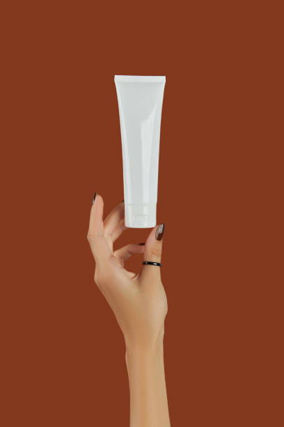 istock Womans hand with cosmetic cream or cleanser on brown background 1367413554