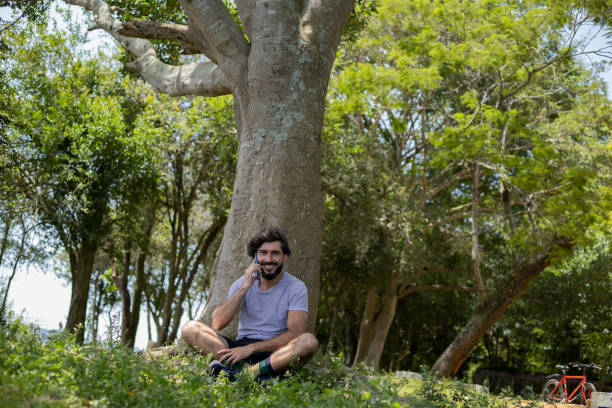 istock Young man at a park on a beautiful sunny day with laptop on his lap. 1367415749