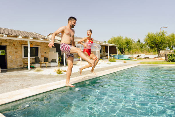 istock Couple jumping into a pool 1367416418