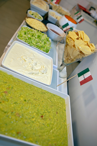 Buffet of dishes of Mexican food, decorated with flag, in restaurant self service