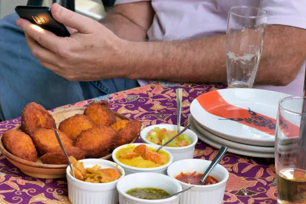 Photo of Acaraje with man handling the cell phone