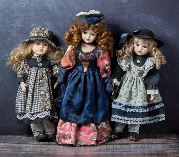 старые винтажные фарфоровые куклы на темном фоне. понятие времени. стоковое фото. элегантные платья. - baby doll dress стоковые фото и изображения
