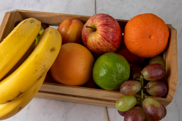 istock Crate with varied fruits, in warm tones, on white background 1367431641
