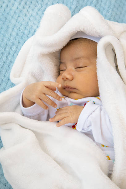 dormindo uma siesta quente com um chapéu e cobertor um bebê latino bonito, estilo de vida infantil, cuidados com o recém-nascido - baby boys clothing hospital simplicity - fotografias e filmes do acervo