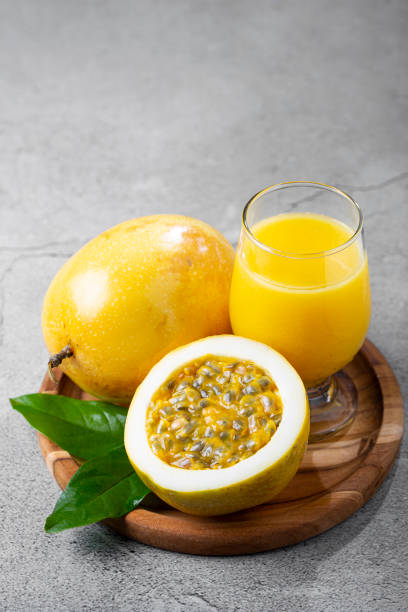 istock Glass with passion fruit juice and sliced passion fruit on the table. 1367432570