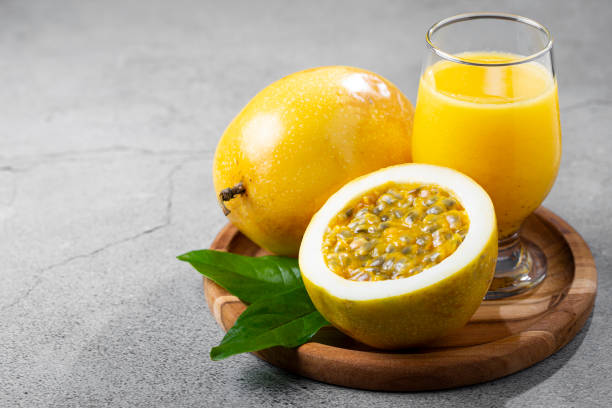 istock Glass with passion fruit juice and sliced passion fruit on the table. 1367432571