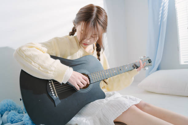 Young Asian women playing guitar