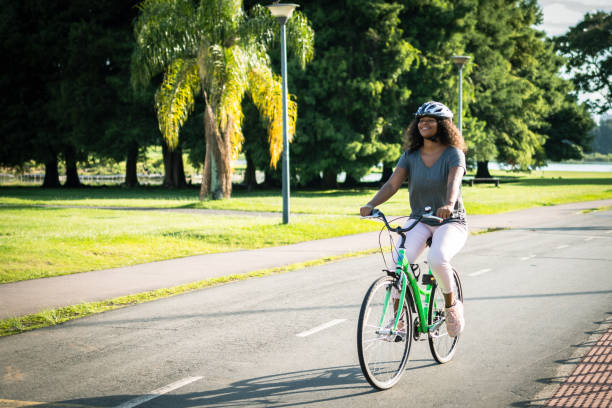 istock Joyfully a young woman rides her green bicycle 1367438304