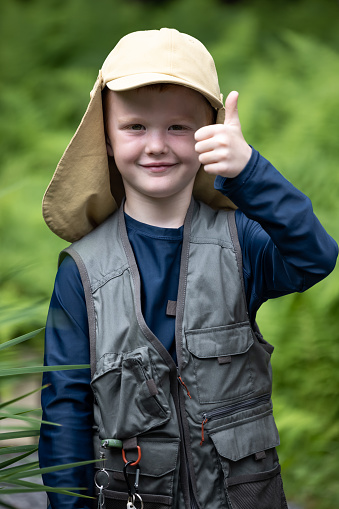 Cute Redhead Boy Ready to go Fishing. He is doing a thumbs up sign and looking at the camera and smiling.