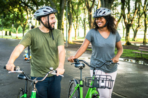 istock Two people look at each other and smile while pushing their bikes 1367439466