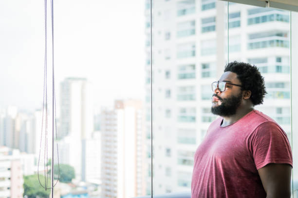 istock Between the windows a man looks at the horizon 1367441007