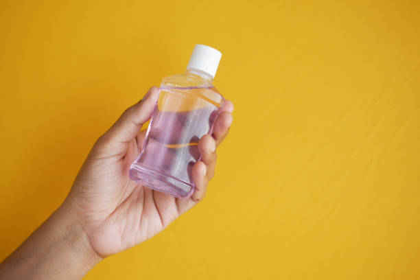 istock hand hold a mouthwash liquid container against blue background 1367441262