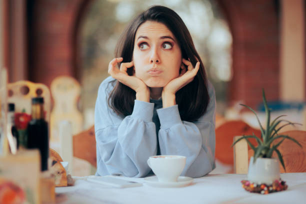 mujer molesta cubriéndose los oídos en un restaurante ruidoso - hand to ear fotografías e imágenes de stock