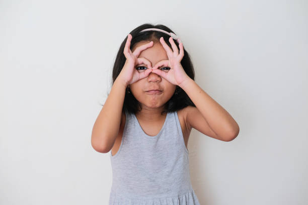 Asian kid showing funny expression when looking to the camera