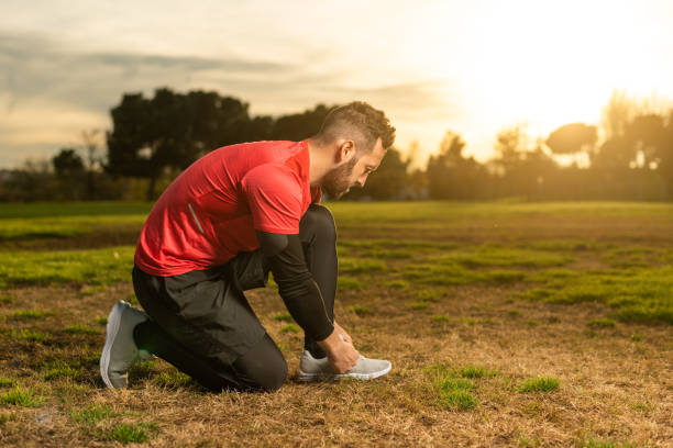 istock Sportsman tying shoelaces before running training on lawn 1367459087