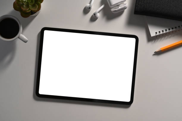 istock Mockup digital tablet with blank screen, wireless earphone and coffee cup on white table. 1367460820