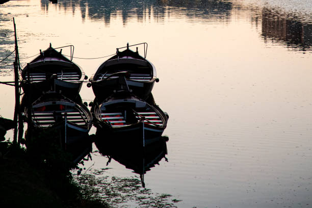 Rowing boats tied up on a river beneath a bridge