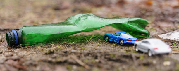 people ride their cars on vacation, passing through an arch made of a plastic bottle - a symbol of pollution. - toxic substance spilling pouring bottle imagens e fotografias de stock