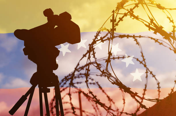 istock Double exposure - camera, barbed wire and flag Venezuela 1367464429