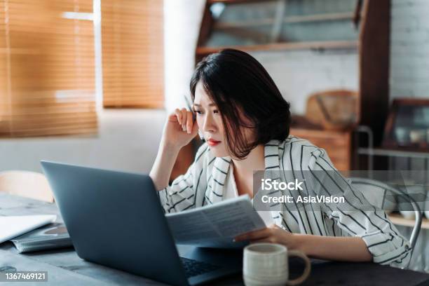 Young Asian Woman Handling Home Finances With Laptop Looking Worried While Going Through Financial Bills Financial Plan Tax Spending And Budgets Financial Problems Concept Stock Photo - Download Image Now