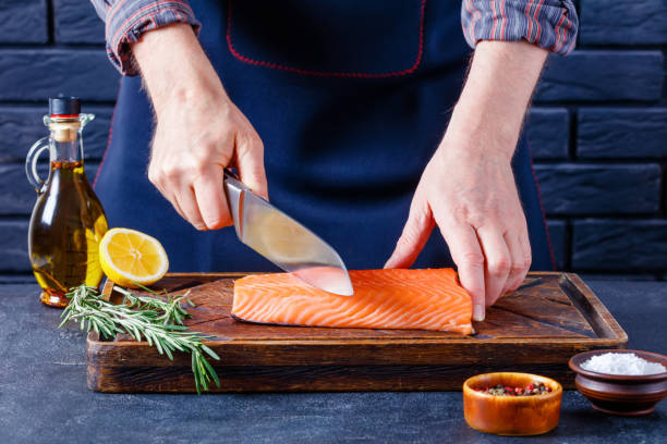 istock Man is cutting salmon fillet., top view 1367472286