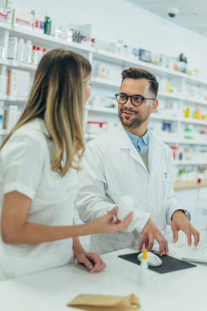 istock Young female pharmacist holding medications in her hand 1367475443