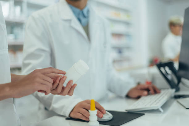 istock Young female pharmacist holding medications in her hand 1367475501
