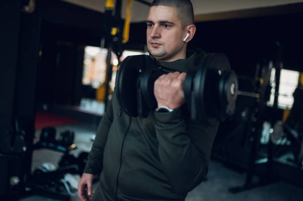 istock Man training in the gym and lifting dumbbells 1367475522