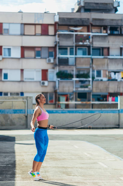 istock Attractive young woman using a fitness jump rope while training outside 1367475537