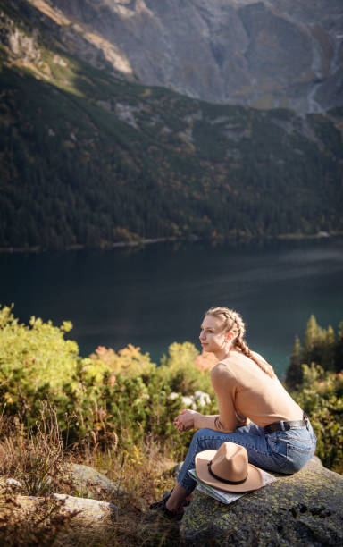 istock Young woman on a hiking trip sitting on a rock 1367479270