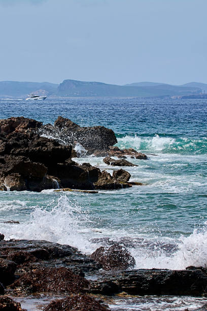 rochers sur le rivage frappés par la vague - water surface emotional stress shape nature photos et images de collection