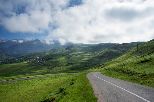 Road of green mountains and cloudy sky