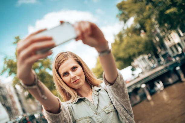 istock beautiful woman take a selfie in amsterdam 1367484217