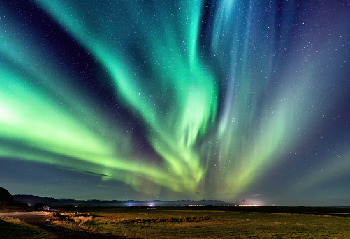 Northern lights, Aurora Borealis in the night sky, Iceland. These colourful curtains of dancing lights can illuminate the night sky in shades of green, blue and yellow.