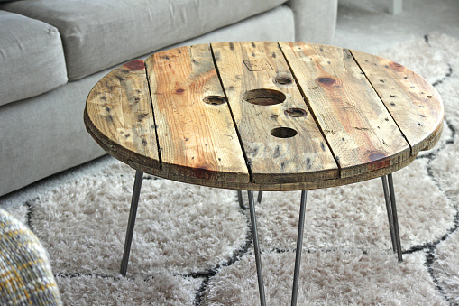 A recycled coffee table made from wooden pallets in a home setting. Rustic, industrial furniture style.