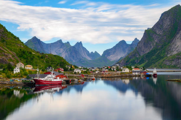 villaggio di reine con barche da pesca e montagne sulle isole lofoten, norvegia - lofoten and vesteral islands foto e immagini stock