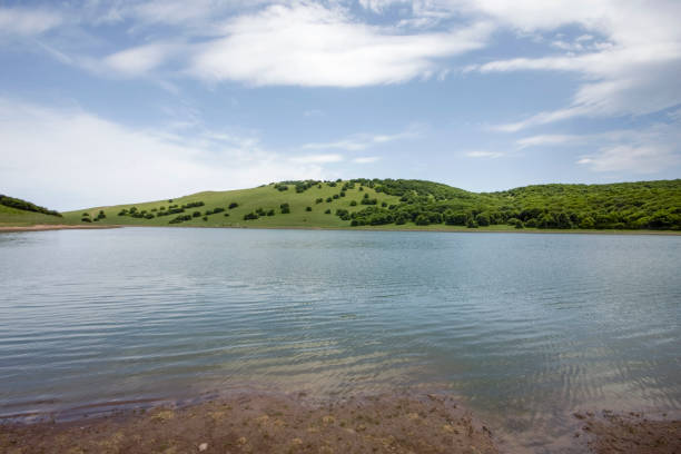 Green lake and mountain with cloudy sky