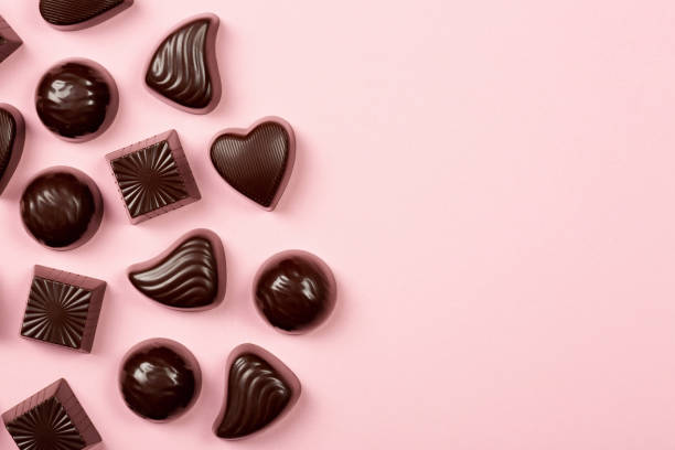 istock Chocolate pralines assortment on pink background 1367489540