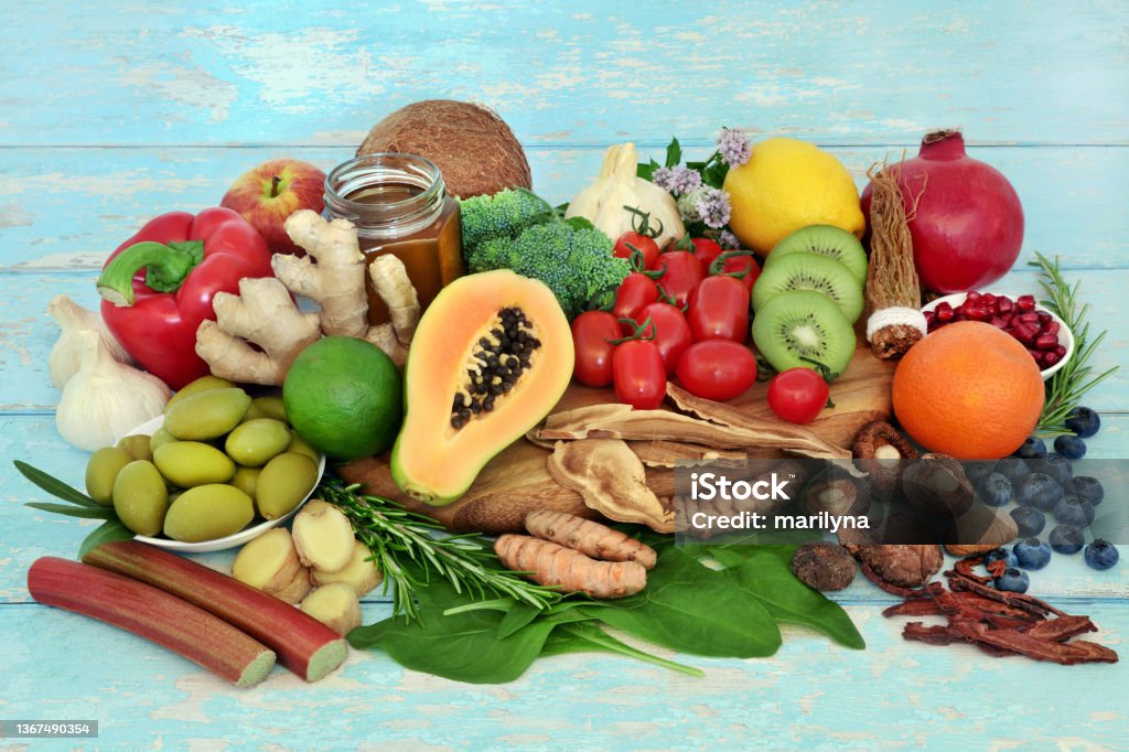Vegetarian Health Food for Immune System Support Vegetarian health food for immune support, vegetables, fruit, honey, herbs, spice. Healthy foods high in antioxidants, anthocyanins, protein, fibre, flavonoids, vitamins, minerals and omega 3. On rustic wood. Fruit Stock Photo